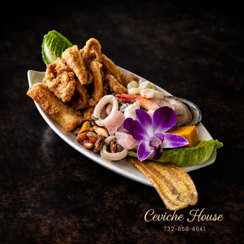 Seafood platter with fried fish, calamari, shrimp, mussels, vegetables, lettuce, and purple orchid garnish on a white plate.