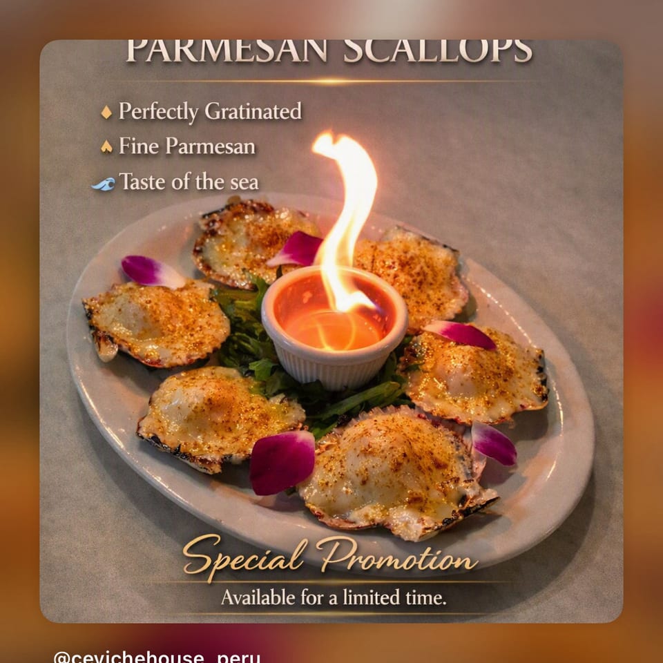 Parmesan-crusted scallops arranged around a flaming dipping sauce, garnished with greens and rose petals in a special promotion display.